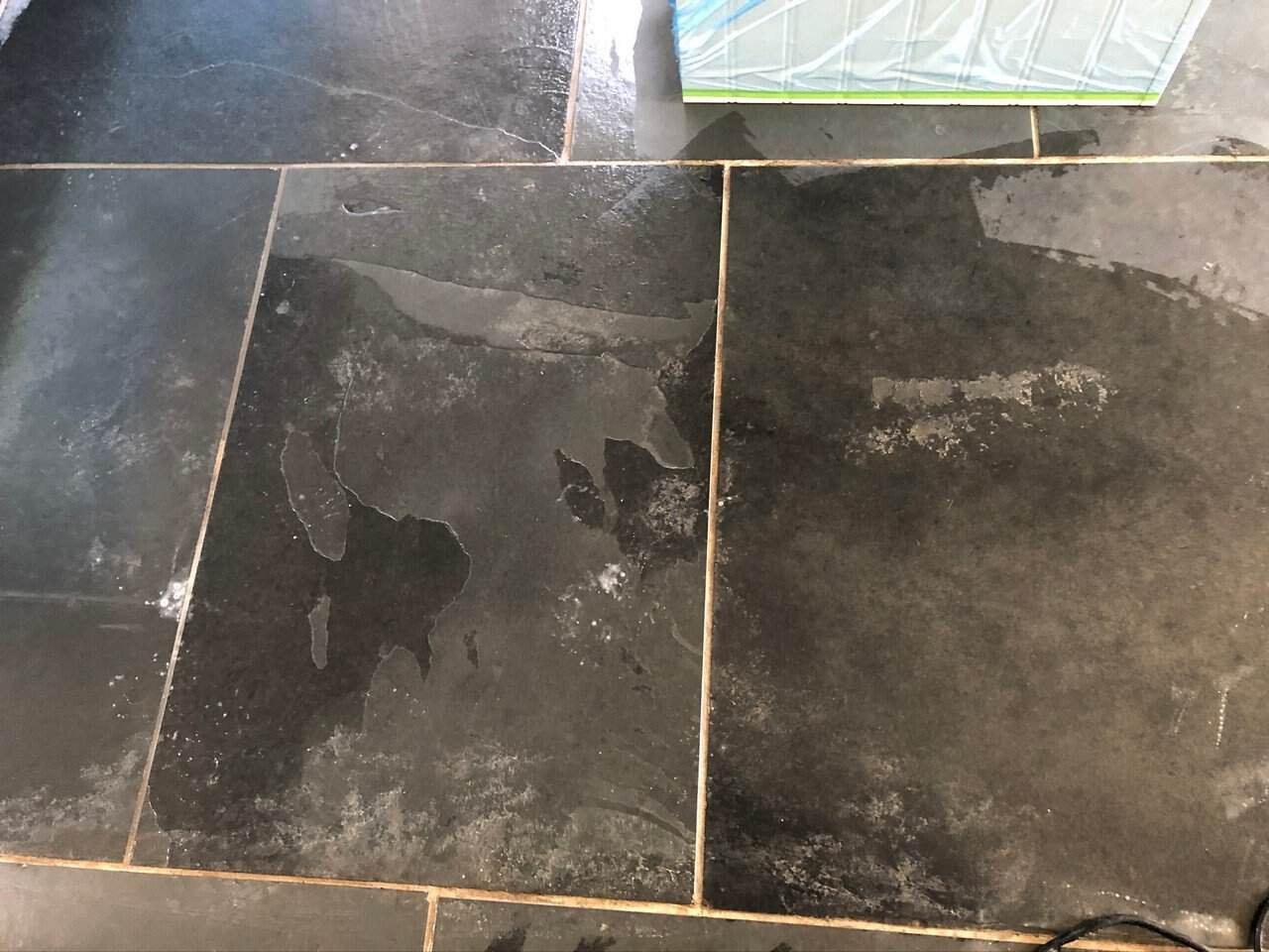 Soiled slate floor with dark grout lines before professional cleaning
