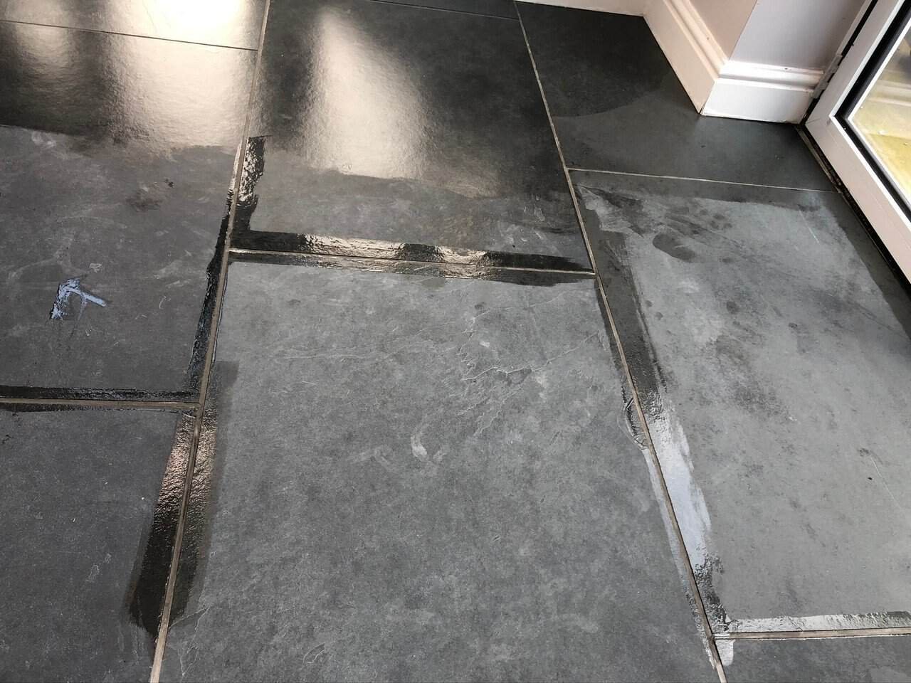 Restored slate floor with sealed surface and clearer grout lines